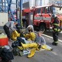 Jako první dorazili na místo zásahu profesionální hasiči  SD -  Dolů Bílina. Na snímku se v bezpečné vzdálenosti převlékají do protichemických obleků. (ČEZ, Ota Schnepp)